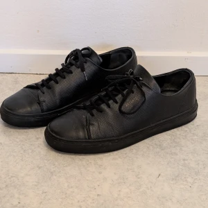 Axel Arigato Premium Lädersneakers – Unik Design, stl 42 - Axel Arigato (Clean 90-modell), svarta, stl 42.  Säljer ett par välgjorda lädersneakers från Axel Arigato i storlek 42. Dessa är en specialutgåva med unik brodyr som gör dem till ett blickfång. Innermått ca 26,5cm. Nypris 2649 kr