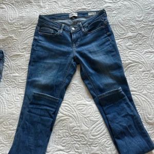 Skinny jeans från ONLY, strl 27/32 - Snygga blå jeans från ONLY i modellen Coral super low skinny. Jeansen har låg midja, smal passform och klassisk femficksdesign. Tillverkade i stretchigt denim för en bekväm känsla. Är i bra skick, en liten liten skada (se bild).