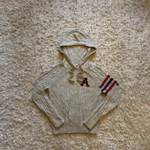 Stickad hoodie från Abercrombie & Fitch - Riktigt snygg stickad hoodie med unika detaljer. Den är i väldigt bra skick men lite nopprig på vissa ställen som med allt stickat vilket syns på sista bilden. Storlek S, tveka inte på o skriva vid fler frågor!