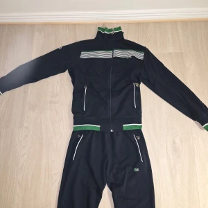 Svart track jacket från Lacoste - Säljer nu en tracksuit från Lacoste i väldigt fint skick. Perfekt för en sportig och snygg outfit. Passa på och fynda🚀