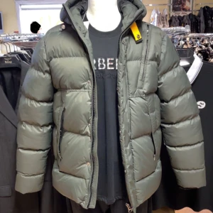 Parajumpers Men’s Cloud Pufferjacka L - Säljer en grå pufferjacka från Parajumpers med huva, ikonisk gul detalj vid halsen och patch på ärmen. Jackan har flera dragkedjor, quiltad design och är tillverkad i syntetmaterial. Perfekt för kalla dagar och har en riktigt schysst streetstil. Storlek L, känns mer som M. Ej använd.