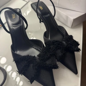 Svarta pumps med rosett från Zara - Skit snygga klackar från Zara med spetsig tå, smal klack och dekorativ fransig rosett framtill. Aldrig använda utomhus💞