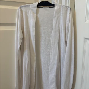 Vit kofta i bomull  - Lätt och stilren vit Cardigan i mjuk bomull. Koftan har öppen front utan knäppning och långa ärmar. Använd endast en gång!🥰