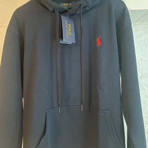 Mörkblå hoodie från Polo Ralph Lauren - Snygg mörkblå hoodie från Polo Ralph Lauren,Väldigt skön och passar bra,den är i storlek S och är i nyskick.