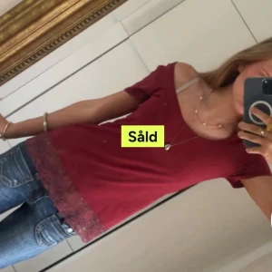 Vinröd topp med spetskant - Vinröd topp med kort ärm och bred, rund urringning. Nedtill finns en bred spetskant i matchande vinröd nyans som ger en extra detalj. Toppens material är mjukt och lätt, perfekt för en chill look. Köpte på Plick men kommer tyvärr inte till användning!❣️