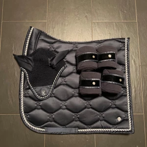 Schabrak  - Ps of Sweden dressyrschabrak Signature Navy strl full. Har lite hår på insidan. Är tvättat. Nypris 800kr. Ps of Sweden huva Signature Navy strl full. Är tvättad. Nypris: 400kr. ps of Sweden fleece lindor strl full ruffle signature navy. Nypris: 500kr.