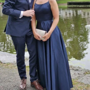 Balklänning  - Jätte fin marinblå balklänning med glansigt material.  Öppen rygg med knytning ibak. Går precis till marken på mig som är ungefär 160cm. Bara att fråga för mer information eller fler bilder🌸Endast andvänd 2 gånger 