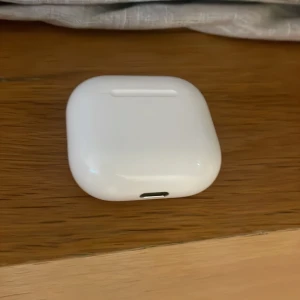 AirPods (4nd generation) - Apple AirPods (2nd gen) med laddningsetui. Fodralet är i gott skick med mindre repor, inga synliga större skador. Perfekt för trådlös musik och samtal med enkel anslutning till Apple-enheter.