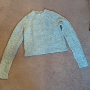 Ljusblå stickad tröja med croppad passform - Supermysig ljusblå stickad tröja med croppad passform och långa ärmar. 