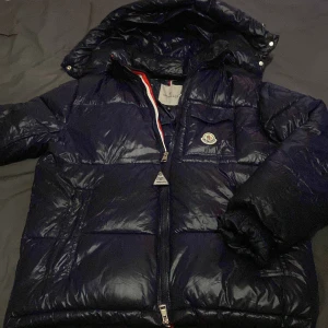 Mörkblå Moncler dunjacka med huva - Riktigt fet Moncler puffer, den är håller dig varm och du ser bra ut samtidigt, puffig och glänsig. Går att scana kan lösa fler bilder om man är intresserad! Den är som en M i puffig het om du fattar och lite som en S i längd!