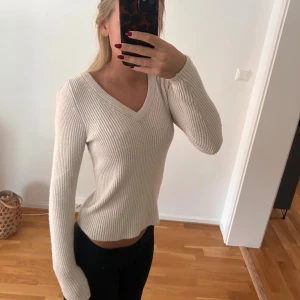 Stickad tröja - Säljer en beige stickad tröja som är ribbad och v-ringad. Bra skick