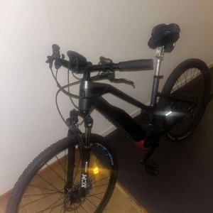 Moustache Samedi 27 Trail E-MTB - Moustache Samedi 27 Trail elcykel med Bosch Performance-motor. Svart ram, dämpad framgaffel, sportig sadel och display på styret. Cykeln ser välvårdad ut med minimalt slitage, perfekt för både pendling och terräng. Batteriet är integrerat i ramen för snygg design laddare finns samt. 