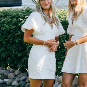 Vit kort klänning med puffärm - Säljer en vit kort klänning med snygga puffärmar och v-ringad hals. Klänningen har ett strukturerat tyg. Från Gina Tricot. Perfekt studentklänning. Använd en gång men är i ett super fint skick. Nypris 600kr