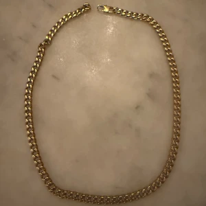 Guldfärgat halsband från Edblad - Kedjehalsband från Edblad i guldfärg med klassisk, chunky länkdesign. Snyggt och stilrent smycke som ger en cool touch till din outfit. Levereras i originalask från Edblad.