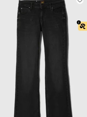 Svarta bootcut jeans från Lee  - Snygga svarta jeans från Lee med bootcut-snitt och klassisk femficksdesign. Jeansen har en mörk tvätt och är tillverkade i mjukt denim-material som sitter skönt. Perfekta för dig som gillar en lite vidare passform nertill. Dessa är i storlek w25 L31.