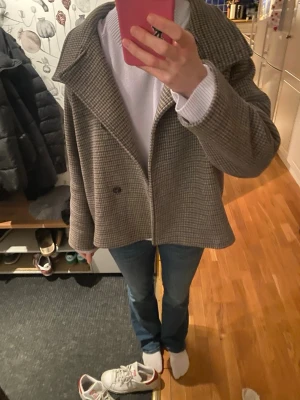 Rutig kappa - Rutig kappa från Gina tricot i ull. Super skön och är varm. Har lite noppror under armen men annars har den inga tecken på användning 