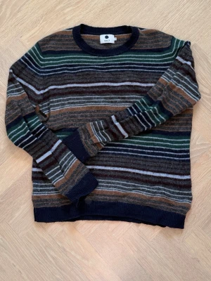 Randig stickad tröja från NN07 - Säljer en snygg stickad tröja från NN07 i storlek M. Sparsamt använd. Nypris 1900