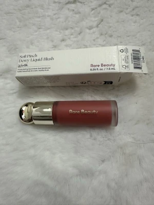 Rare Beauty Soft Pinch Dewy Liquid Blush - Flytande rouge från Rare Beauty i nyansen Worth. Kommer i en snygg frostad flaska med guldfärgat lock och har en mjuk, rosad ton. Perfekt för att ge kinderna en fräsch och naturlig glow. Innehåller 7,5 ml.