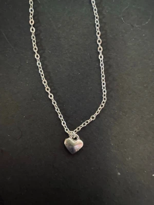 By prisförslag- silvrigt Halsband med mini hjärta 45 cm längd - Silvrigt halsband med ett mini hjärtformat hänge. Väldigt snyggt och diskret. 