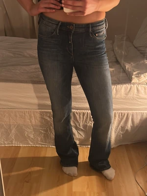 Boot cut jeans  - Säljer ett par boot cut jeans i blå tvätt med bootcut passform. Jeansen har fem fickor, normal midja och snygga slitningar för en avslappnad look. Tillverkade i tåligt denim med Levis ikoniska läderpatch bak i midjan.