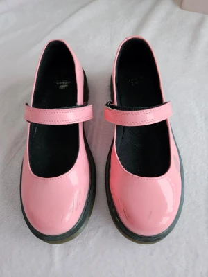 Rosa Dr Martens Mary Janes i rosa lack  - Skorna är i gott skick utöver lite ytliga märken. Se alla bilder. Storlek 36. Rökfritt hem men har katter. 