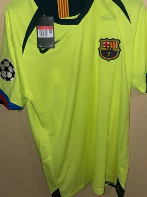 FC Barcelona bortatröja - Ronaldinho #10 - Säljer en klassisk FC Barcelona bortatröja från Ronaldinho-eran i storlek L. Tröjan är gul och har originaldetaljer som Nike-logga, FC Barcelona-emblem samt Champions League-märke på ärmen. En ikonisk tröja för samlare eller fans av Barça och Ronaldinho, passar lika bra att använda som att ha i samlingen. Passar M