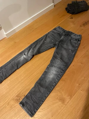 Replay grå skinny jeans 10A - Säljer ett par grå skinny jeans från Replay i storlek 10A. Jeansen har slitningar och en liten reva på ena benet för en cool look. Klassisk femficksmodell med snygga detaljer på bakfickorna. Perfekta till vardagsoutfiten.
