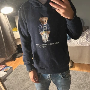 Mörkblå Polo Bear hoodie från Ralph Lauren - Säljer en riktigt snygg och skön raffe hoodie. Hoodie sitter riktigt bra och är riktigt fräsch. Storlek M men passar även S. Hör av er vid frågor