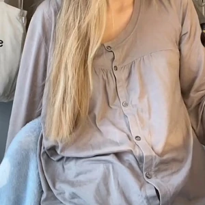 Beige blus med knappar - Säljer en beige blus med rund halsringning och knappar framtill. Blusen har lång ärm och är tillverkad i mjukt bomullsmaterial som känns skönt mot huden. Perfekt för dig som gillar en enkel och avslappnad stil.