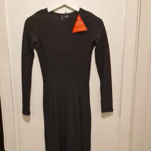 Svart långklänning - Svart långklänning som har en smickrande slim passform och slits på sidorna för extra edge. Perfekt för höstens fester och event.