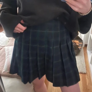 Rutig kjol - Marinblå/grön rutig kjol. Använd men bra skick. Går att vika upp och få kortare.