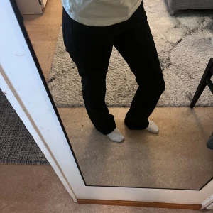 Svarta bootcut jeans - Säljer ett par svarta jeans från Gina Tricot med bootcut-modell. Byxorna har hög midja och raka ben. Färgen är helt svart, vilket gör dem enkla att matcha.