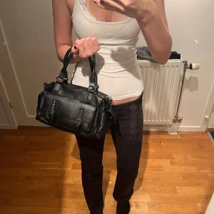 Svart handväska med nitar - Cool svart handväska i skinn med silverfärgade nitar. Super snygg🥹 