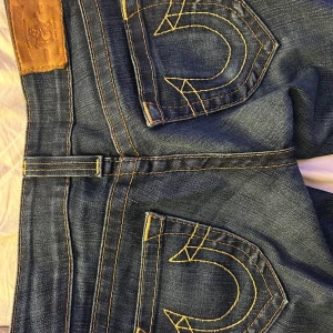 Bootcut true religon jeans. - Säljer ett par bootcut jeans ifrån true religon. Köpte dessa på Vinted i sommras och har använt de ungefär 5-10 gånger. DetTjejen innan sa att hon hade använt ungefär lika många gånger men nu har jag sprätt upp byxan i längden men är lätt att sy upp om man vill😊. Jeansen är i storlek 25 och är inget större ”fel” förutom då uppsrättningen.säljer då jag växer så fort och dem har blivit för korta.