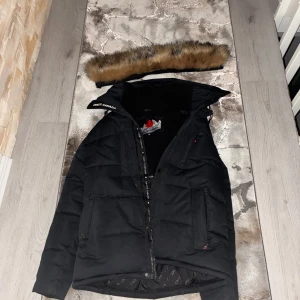  Zavetti Canada jacka - Svart pufferjacka från Zanetti Canada med avtagbar fuskpäls på huvan. Använt jackan i ungefär bara en månad så jackan är inte jätte använd.