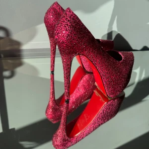 Höga platå Klackskor Rosa, Strl 39 - Säljer nu mina fantastiska rosa klackskor likande Louboutins. Täckta med gnistrande rhinestones och har den ikoniska röda sulan. Dem är knappt använda har mer haft skorna som en fin prydnad på skohyllan  -Storlek 39 -Klackhöjd 16 cm  -Platå 7 cm