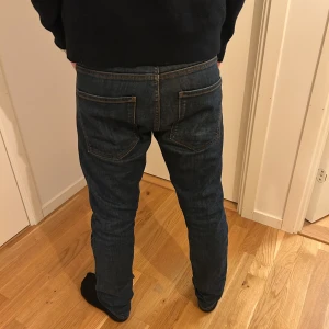 Mörkblå jeansbyxor slim fit - Snygga mörkblå Oscar Jacobson jeansbyxor med klassisk femficksdesign och smal passform. Jeansen har raka ben, normal midja och är tillverkade i slitstarkt denimtyg med subtila kontrastsömmar. Perfekta för dig som gillar en stilren och enkel look.