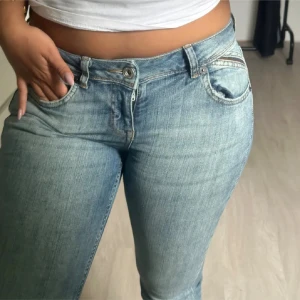 Bootcut jeans från BDG Urban Outfitters - Snygga ljusblå bootcut jeans från BDG Urban Outfitters. Jeansen har låg midja, klassisk femficksdesign och är tillverkade i mjukt denim. Perfekta för dig som gillar en retro vibe och vill ha ett par jeans med utsvängda ben.