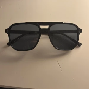 Svarta pilotbågar solglasögon - Snygga svarta solglasögon med pilotformade bågar och svarta glas. Grisch