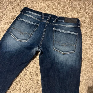 Replay anbass hyperflex jeans slim fit herr w31 wash - Replay anbass hyperflex jeans i slim passform. Mycket bra skick, förutom lite ljusa i grenen och knäna se bild. Storlek W31. Skön wash på dessa , postas samma dag som köp eller dagen därpå🙌💯