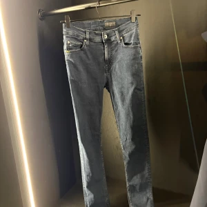 Mörkblå slim jeans med detaljer - Snygga mörkblå skinny jeans från L4 med klassisk femficksdesign och silverfärgade nitar. Jeansen har en smal passform, normal midja och är tillverkade i stretchigt denim för extra komfort. Perfekt för dig som gillar stilrena och moderna jeans.