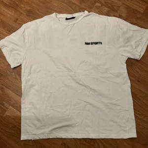 Vit MM Sports t-shirt med tryck - Säljer en vit t-shirt från MM Sports med stort svart tryck på ryggen och mindre logga fram. Använd fåtal gånger. Inga hål eller slitage. ( Den är oversized )