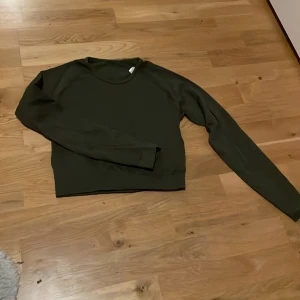 Mörkgrön croppad träningstopp - Mörkgrön croppad, ribbad träningstopp i stl S 