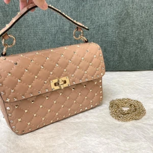 Beige quiltad handväska från Valentino - Snygg beige handväska från Valentino med quiltad design och guldiga nitar. Väskan har ett elegant guldspänne och medföljande kedja som kan användas som axelrem. Tillverkad i skinn med coola detaljer som ger en lyxig vibe.BESTÄLLNINGSVARA TAR 1-3 VECKOR ATT FÅ HEM VÄSKAN) dustbag box får man med!