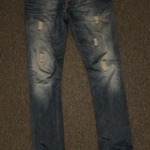 Blå slitna jeans från Nudie Jeans - Säljer ett par blå Nudie jeans. De är i passform grim tim. W30 L34. Kontakta vid fundering:)