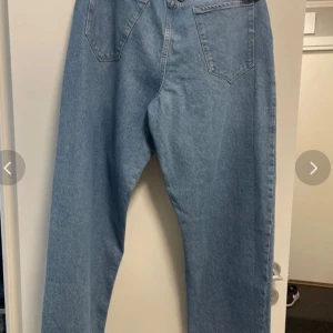Ljusblå raka jeans från selected  - Säljer ett par klassiska ljusblå jeans från Levi's med raka ben och hög midja. Jeansen har fem fickor, bälteshällor och stängs med dragkedja och knapp. Perfekta för en avslappnad och stilren look.