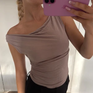 Linne beige  - En fin beige topp med snygg drapering vid halsen. Man kan bära den på flera olika sätt! 