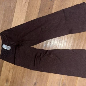 Bruna mjukisbyxor med resårmidja - Mysiga bruna mjukisbyxor med resår i midjan och raka ben. Perfekta för chill dagar hemma eller när du vill vara bekväm. Tillverkade i mjukt material som känns skönt mot huden.