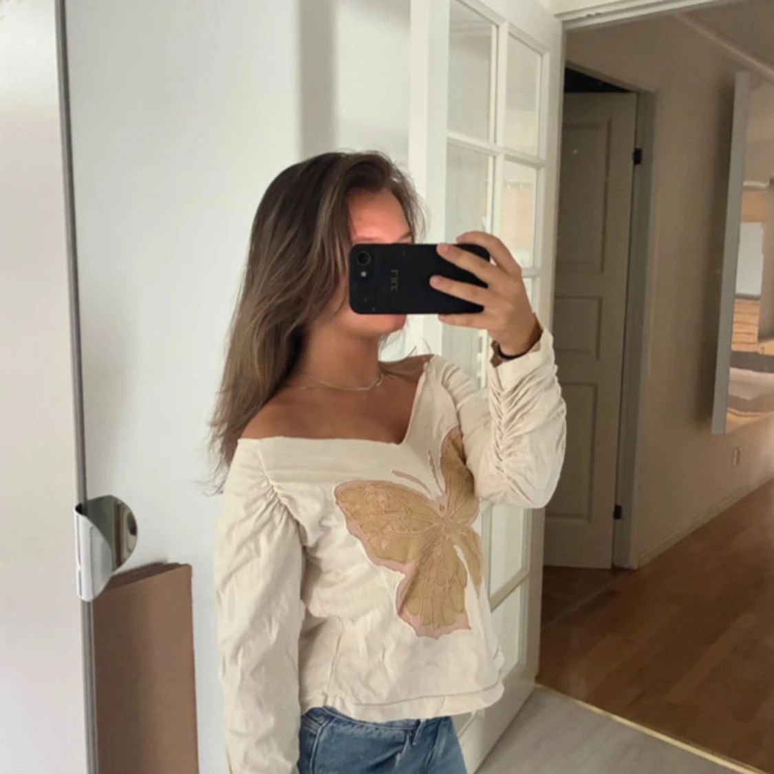 Offshoulder topp med fjäril.