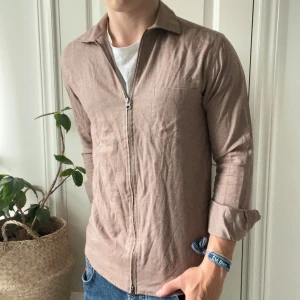 John Henric full zip S / M beige  - John Henric full zip S / M beige , tjock skjort matierall. Modellen är 180,75 kg och bär 14 1/2 37 vilket motsvarar ungefär en M. 😊